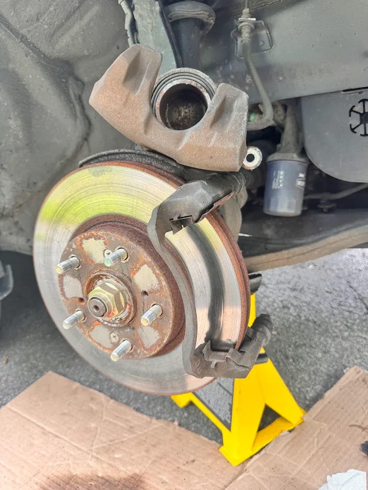 Front brake caliper lifted during pad replacement on a 2005 Honda Accord