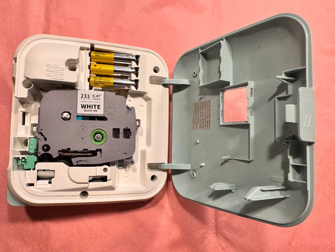 Brother PT-D215e opened with tape cartridge and batteries visible