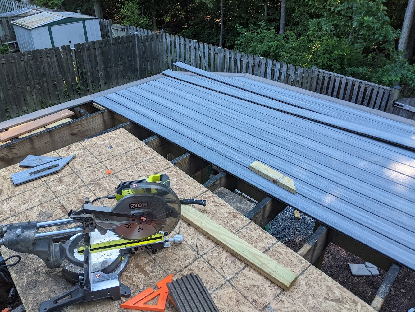 Trex-style composite boards being installed over the deck framing