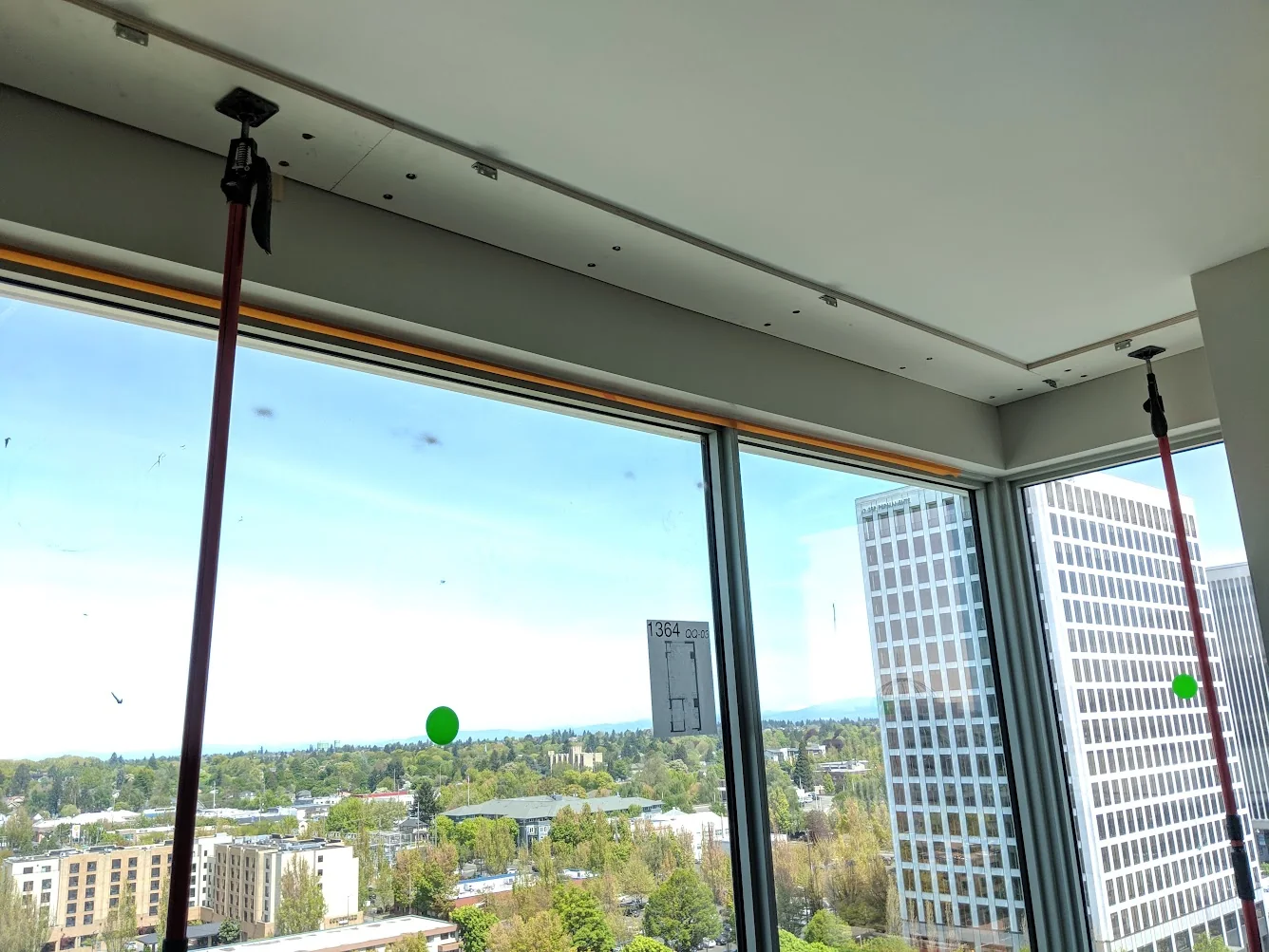 Close view of a FastCap 3rd Hand support pole pressed against a ceiling